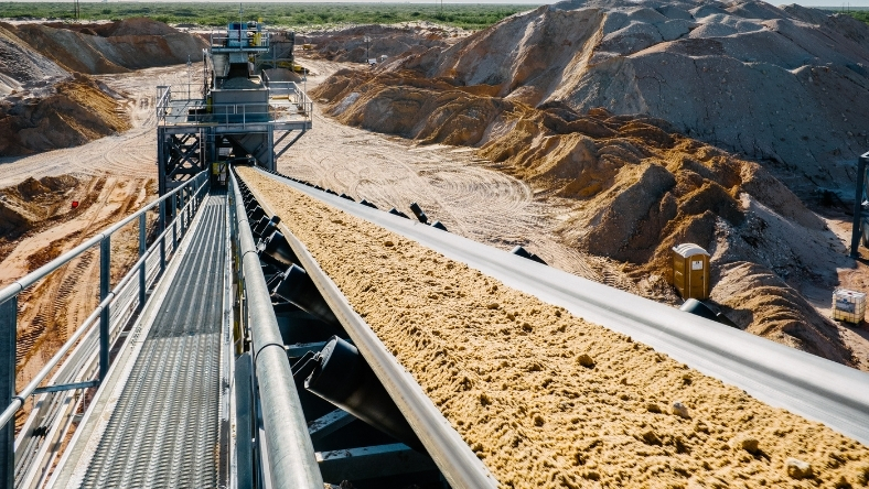 Conveyor system transporting frac sand at onshore processing plant